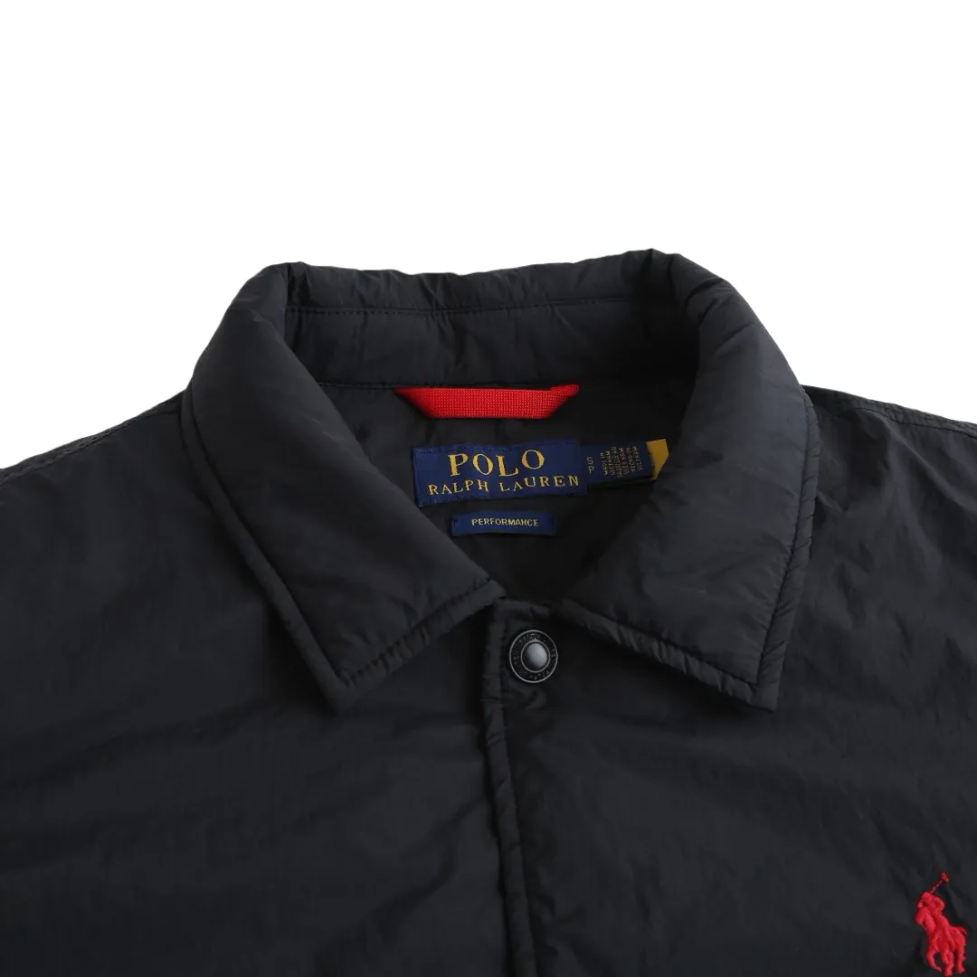 P650 Ralph Lauren pony embroidered light cotton jacket. The fabric is made of high-density nylon taffeta fabric, which combines pragmatism and classic texture. The density is about 210T-300T, the surface is smooth and slightly matte, it has excellent windproof and waterproof properties (with DWR water-repellent treatment), it has strong wrinkle resistance and is easy to care for, which is in line with the positioning of American casual "durable and practical". Classic dark black, using vat dyeing process (dye penetrates into the fiber), the color fastness reaches ISO level 4 or above, preventing fading or color transfer after washing. The lining is made of light cotton-polyester blended fabric (65% Polyester + 35% Cotton) to reduce the friction between the fabric and the inner clothing and improve the smoothness of wearing; the blended material has both breathability and durability to avoid the stuffy feeling of pure nylon lining. The style is a loose fit of the classic Coach Jacket, with slightly dropped shoulder lines (shoulder width is 1-2cm wider than the standard fit). The length reaches the hips, and the sleeves are slightly tapered straight sleeves, taking into account both freedom of movement and casual style. The Polo horse logo on the left chest is flat satin stitch embroidery (satin embroidery). Embroidery thread: 100% polyester high color fastness embroidery thread (the color number is consistent with the brand’s standard red color card). The stitch density is 12-15 stitches/cm. The outline of the horse logo is clear, and the details of the rider and horse are burr-free. The embroidery is positioned accurately through the template (12cm from the bottom of the neckline and 8cm from the placket) to ensure left-right symmetry and centering. The seams of the body are made of double-needle flat seams (needle pitch 3cm/10 needles), the stitches are flat and straight, the stitching color is dark black (the same color as the fabric), and the stitch width is 0.5cm, which enhances firmness while forming simple decorative lines. The front placket is spliced ​​with the body. The placket is made of double-layer folding + flat seam splicing. The thickness is about 0.3cm to ensure that the buttons are not easily deformed when fixed. The edges of the placket are cut with a hot knife to avoid burrs. The armholes where the sleeves and body are joined are made with round-head keyhole machine seams + flat seams. After splicing, the armholes have a natural curvature and no sense of tightness during movement. The height of the sleeves is about 8-10cm, which is in line with the loose characteristics of casual jackets. The main buttons are made of black urea resin buttons with a matte surface. The button holes are hand-made keyholes (6 strands of cotton thread, keyhole density of 8 stitches/mm), and the edges of the eyelets are smooth and without burrs. The first button on the neckline is a hidden button (diameter 12mm), which prevents the neckline from opening and improves the neatness of wearing. Size:S-M-L-XL